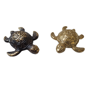 Two brass figurines in the shape of turtles, one with a gold finish and the other with a black and gold finish, against a white background.