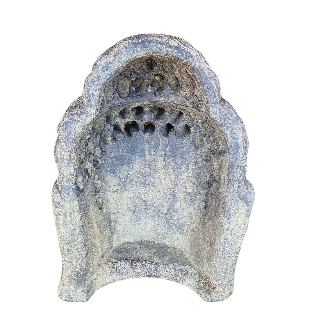 Rear view of a silver-grey concrete wall ornament showing its textured surface, hollow decorative detailing and curved edges against a white background