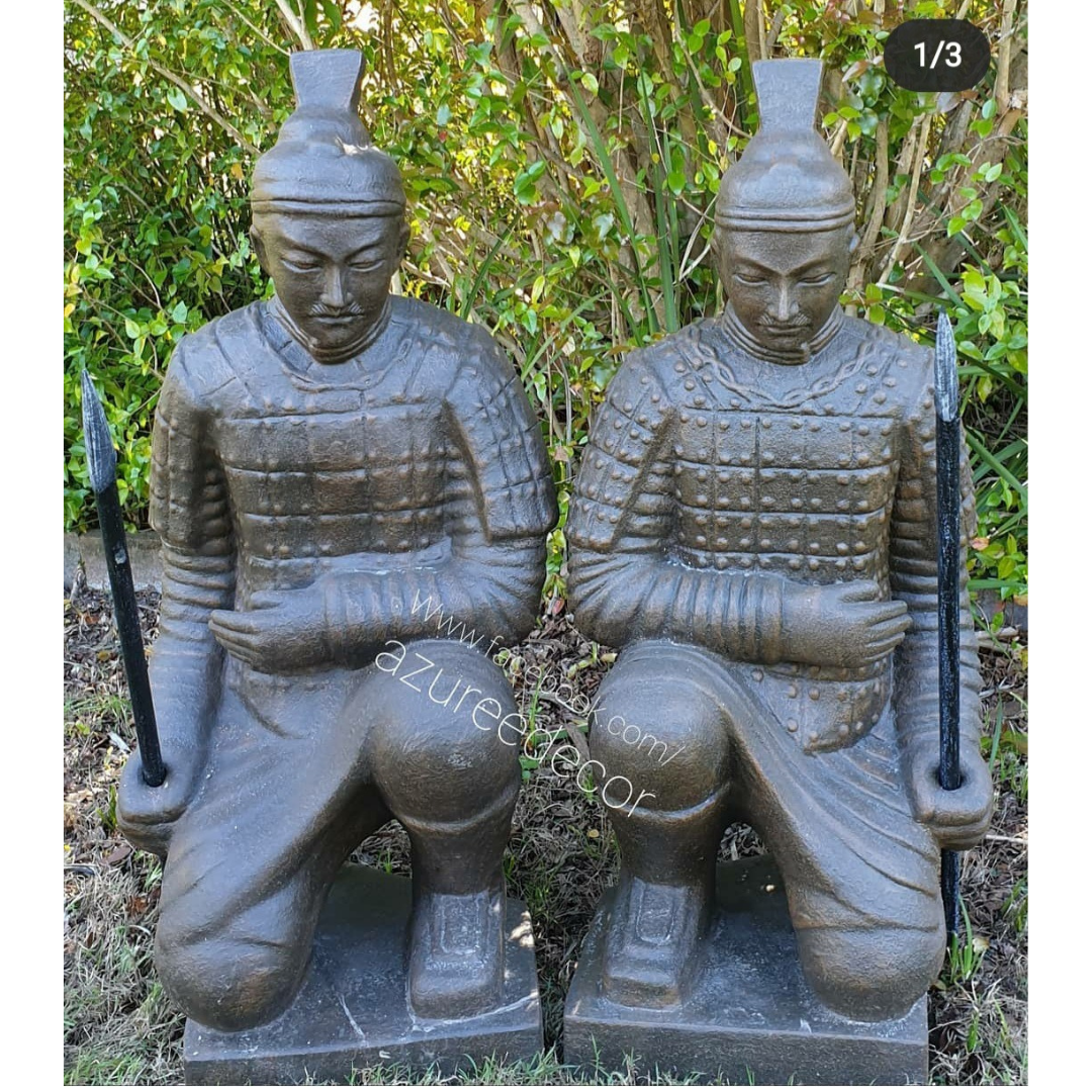 front view of the china warrior statues in front of a garden background