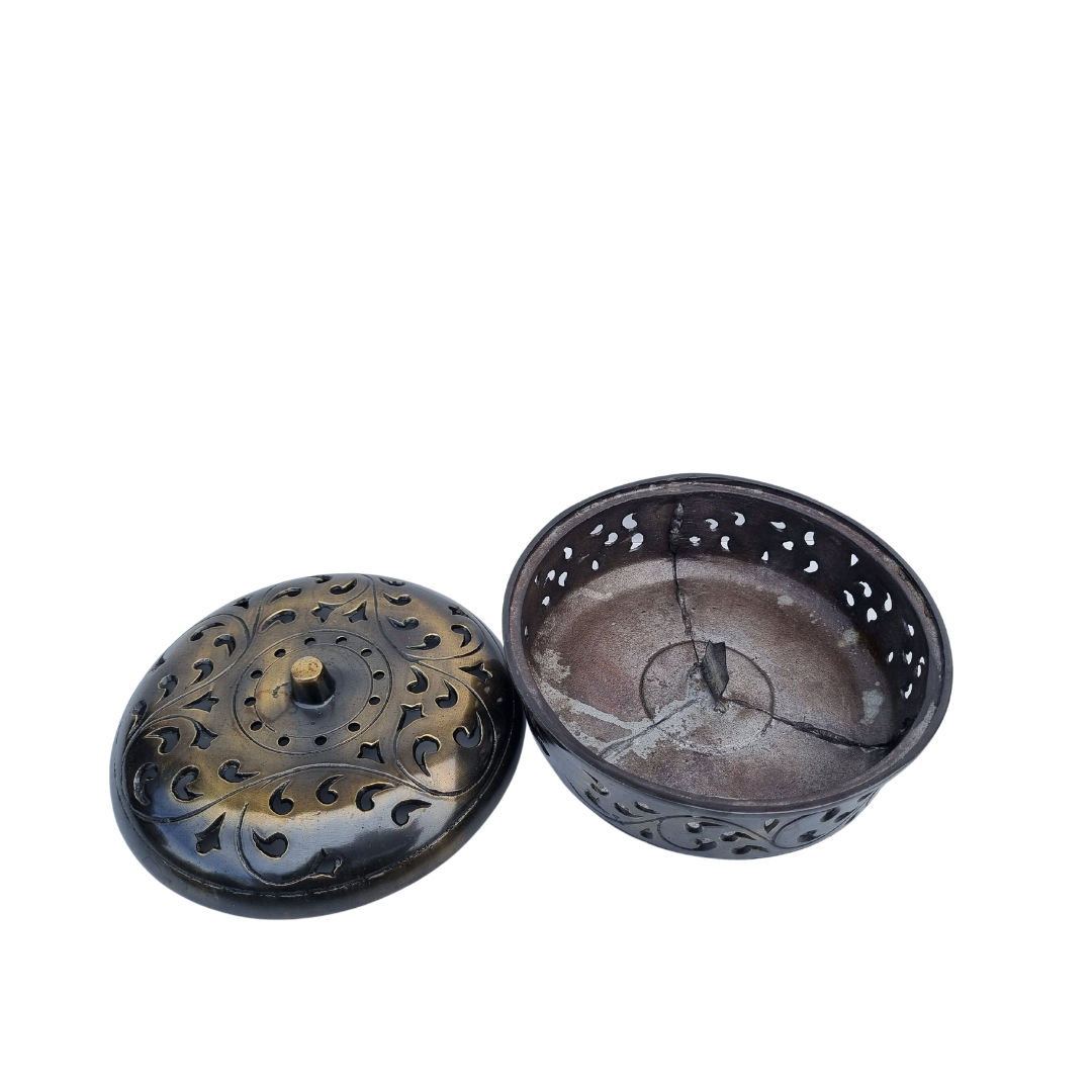 open bronze: Bronze bowl with inner support and wire frame visible, beside a domed lid with pierced scroll details on a white background.